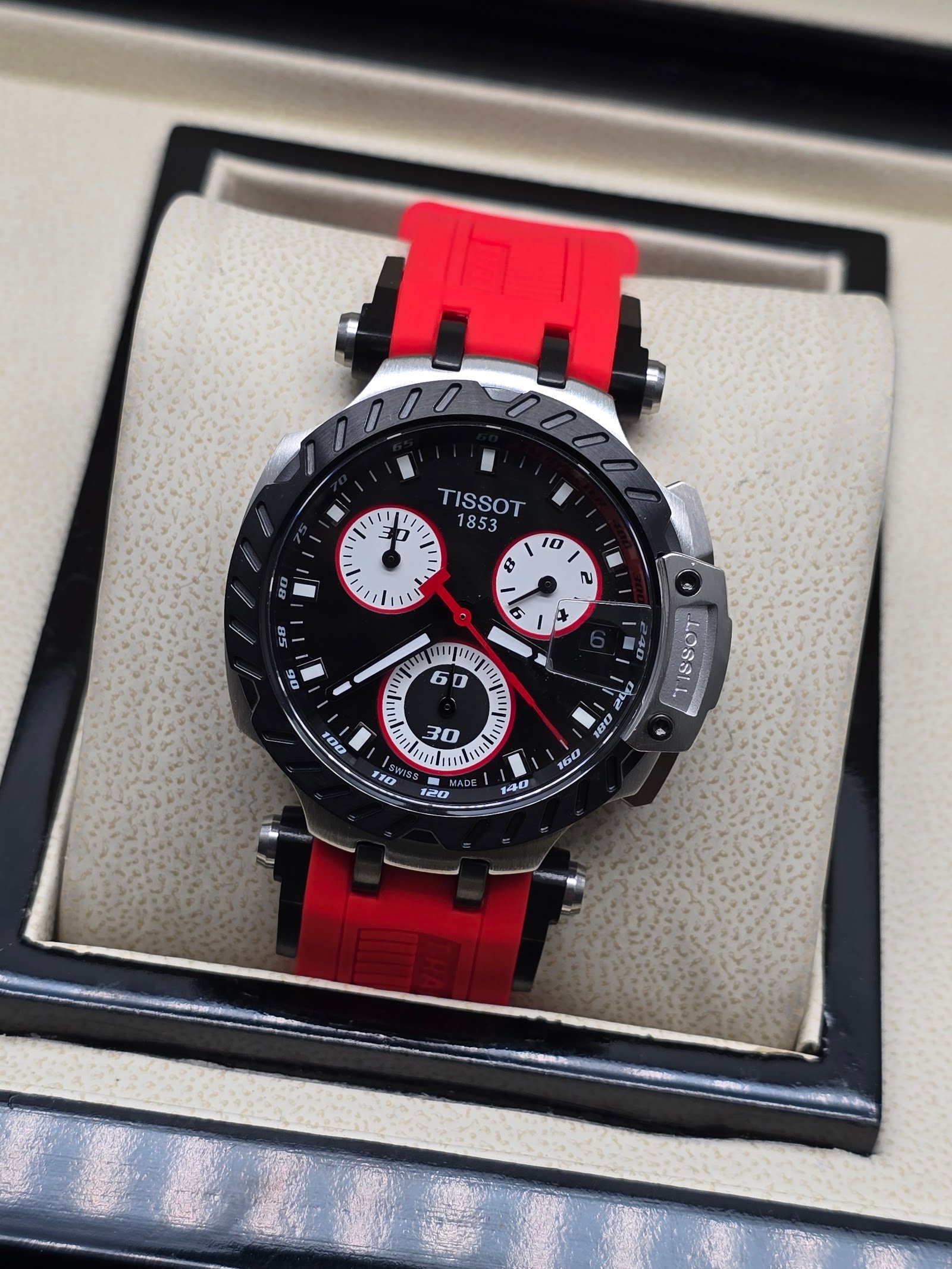 Tissot — cronógrafo con esfera negra y subesferas blancas, correa roja
