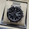 Tissot — cronógrafo con esfera negra, bisel negro y brazalete de malla de acero