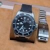 Tudor — esfera negra con bisel negro, correa de caucho y brazalete de acero