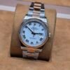 Rolex — esfera blanca con números romanos, bisel rosado y brazalete bicolor